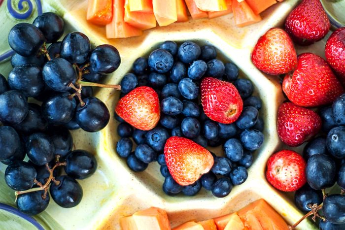 sectioned tray with fruit and vegetables; grapes, carrots, blueberries, and strawberries