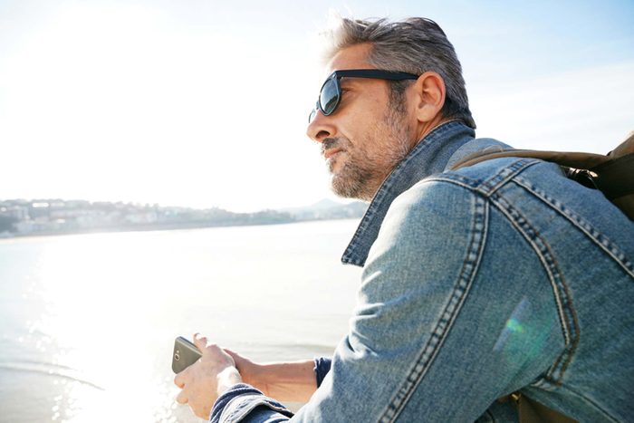 man wearing a denim jacket and sunglass traveling for vacation