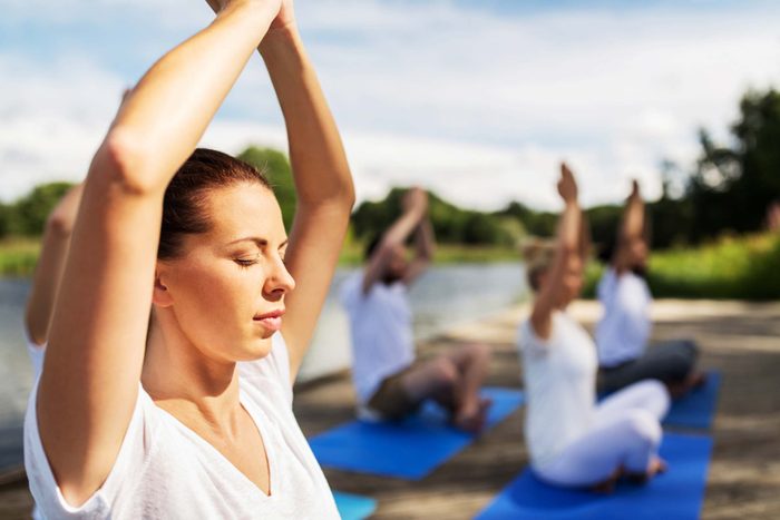 people meditating on yoga mats outdoors