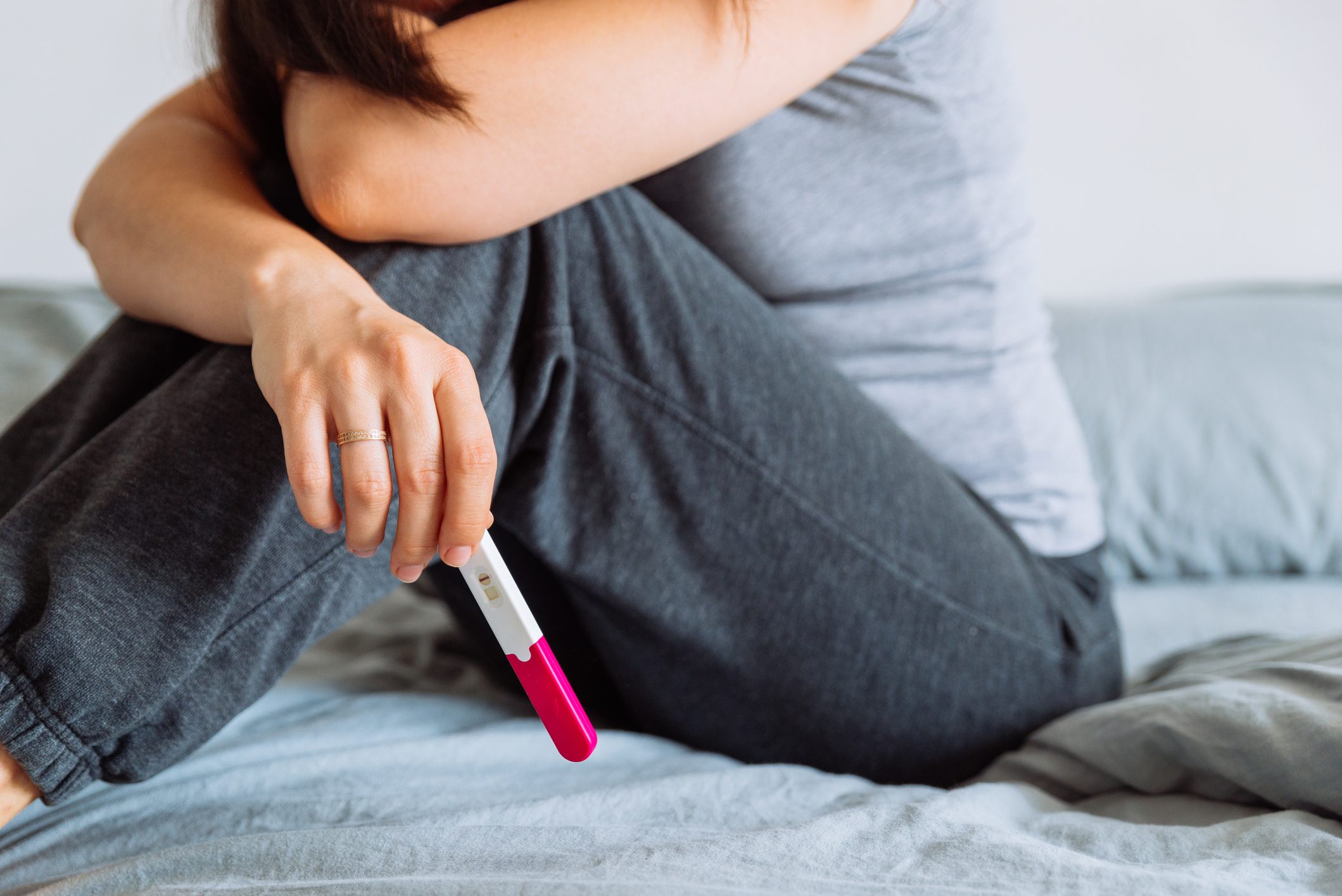 upset woman holding negative pregnancy test