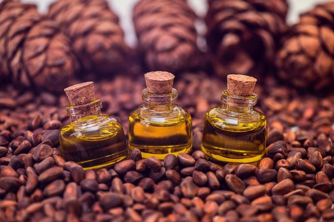 small bottles of oil on cedarwood nuts and cones
