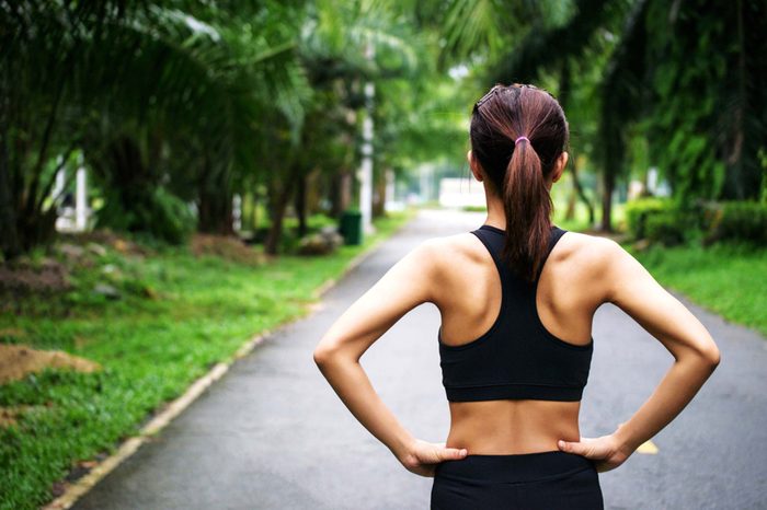 Woman in workout gear outdoors, shot from behind