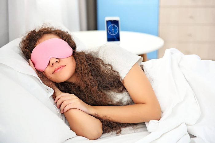 young girl in bed with sleep mask
