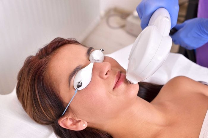 woman wearing eye protection being treated with pulsed light