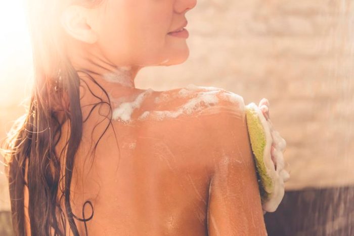 woman looking over her shoulder in the shower, soaping up