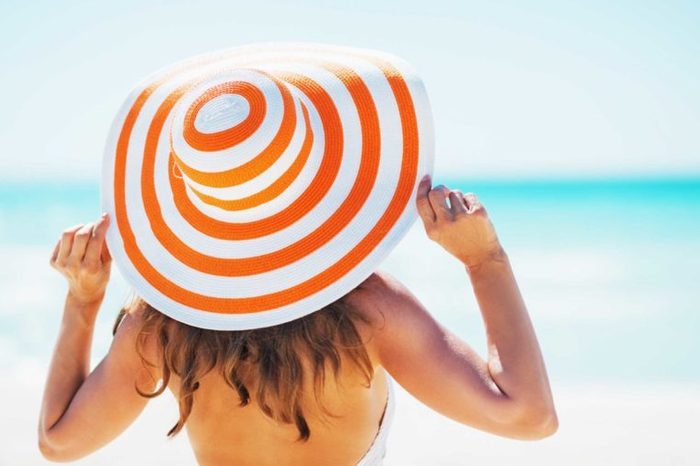 woman at the beach in a colorful sun hat