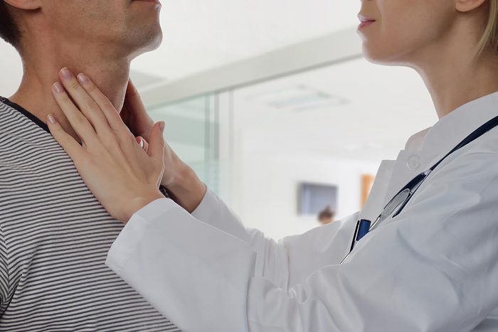 man getting thyroid checked by doctor