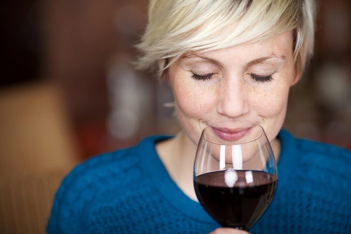 woman sniffing glass of red wine