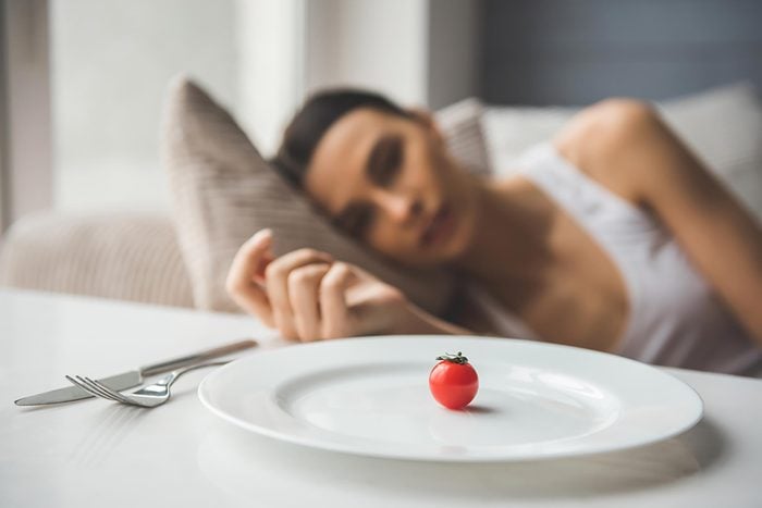 woman looking at tomato on plate