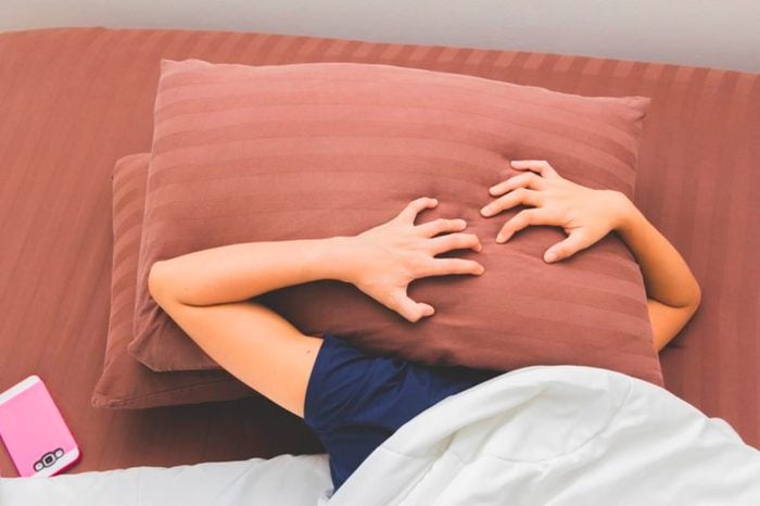 person holding pillow over their head