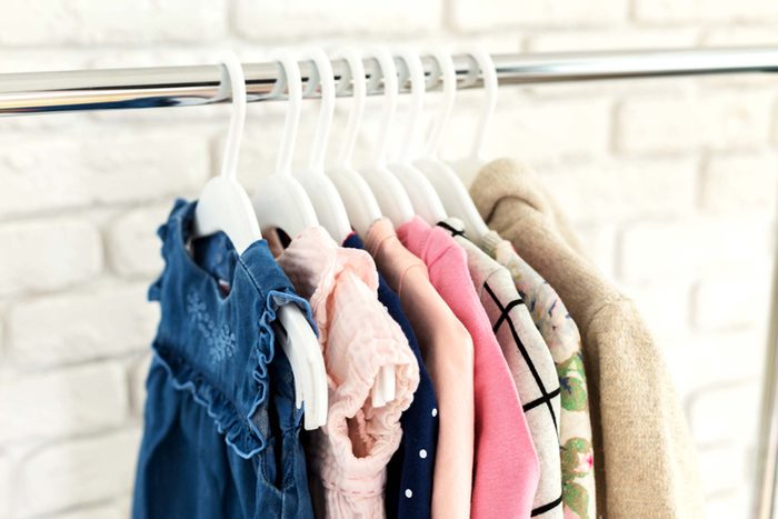 child's clothes hanging in closet