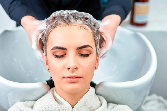 stylist shampooing woman's hair