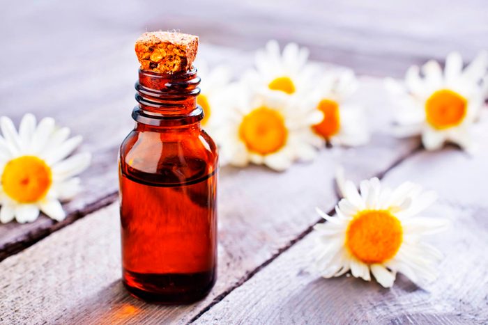 bottle of chamomile oil with blossoms