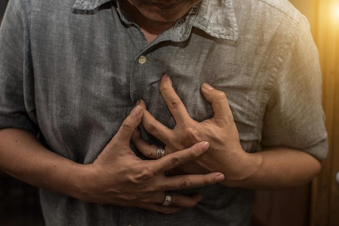 man clutching chest, having heart attack