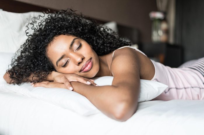 woman sleeping on stomach with smile on her face