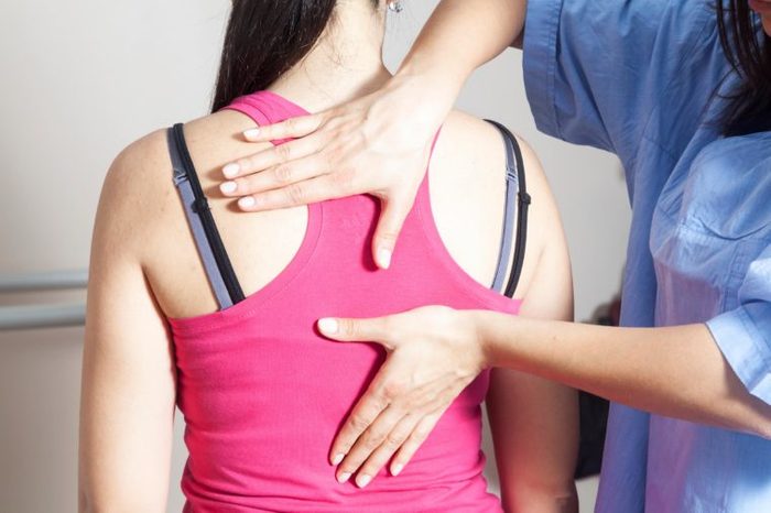 doctor checking woman's spine