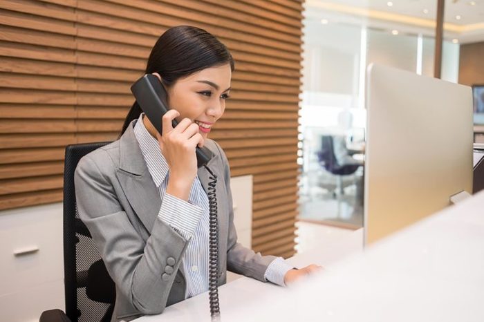 Asian woman in an office speaking on a phone