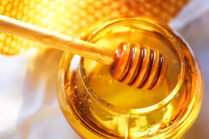 honey jar with a wooden honey dipper