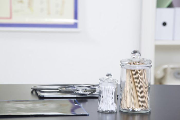 a doctor's office counter with swabs, tongue depressors, and stethoscope