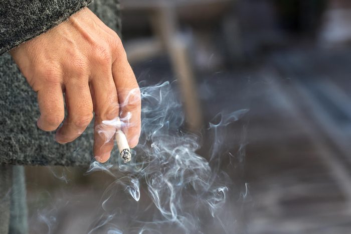 hand holding a lit cigarette