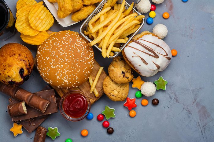 a variety of junk food: fries, burger, chips, candy, cookies