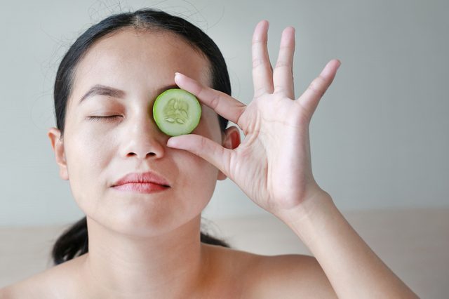 woman and cucumber on eyes dark circles