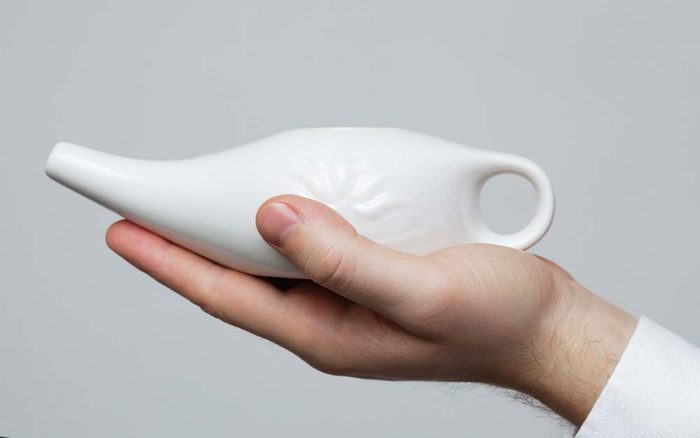 Neti pot in the palm of a hand
