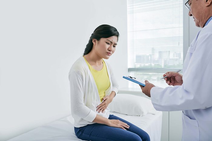 Woman with stomach pain talking to a doctor