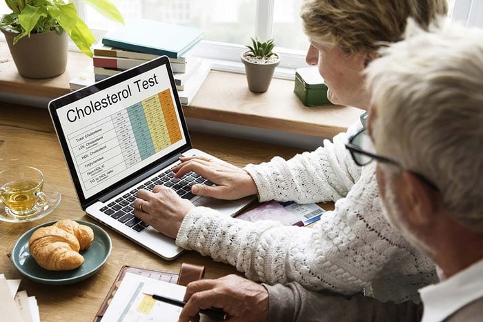woman and man looking at cholesterol test results on a laptop