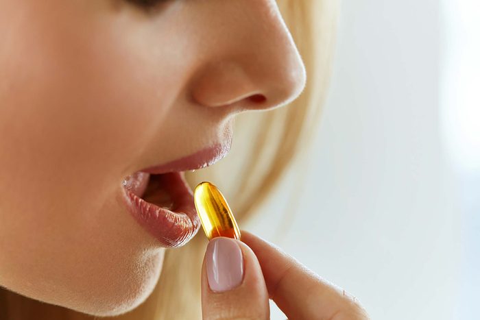 Woman taking an omega-3 supplement.