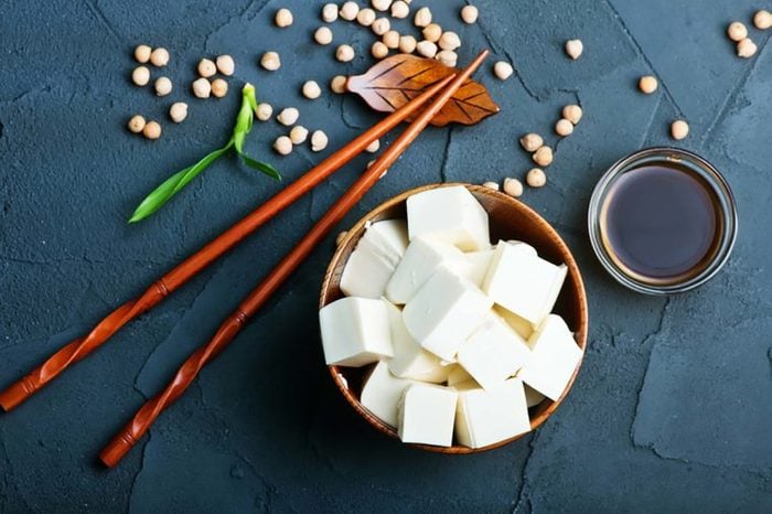 cubed tofu in a bowl with chopsticks and soy sauce