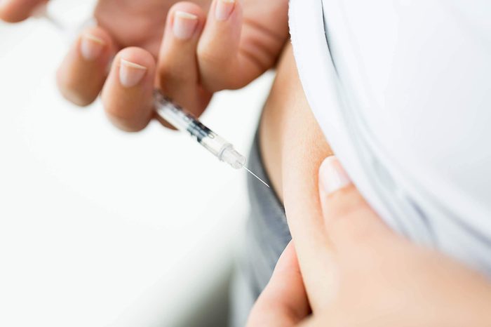 person injecting insulin into abdomen