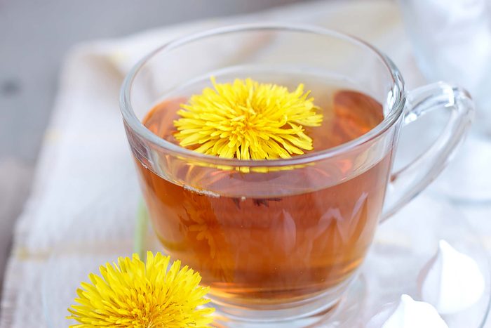 glass cup of dandelion tea with blossom