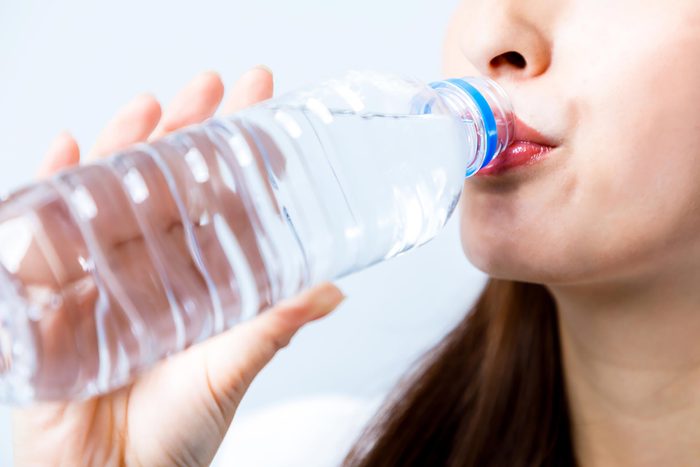 woman drinking out of a water bottle