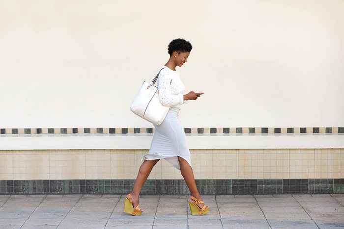 woman walking and looking at phone