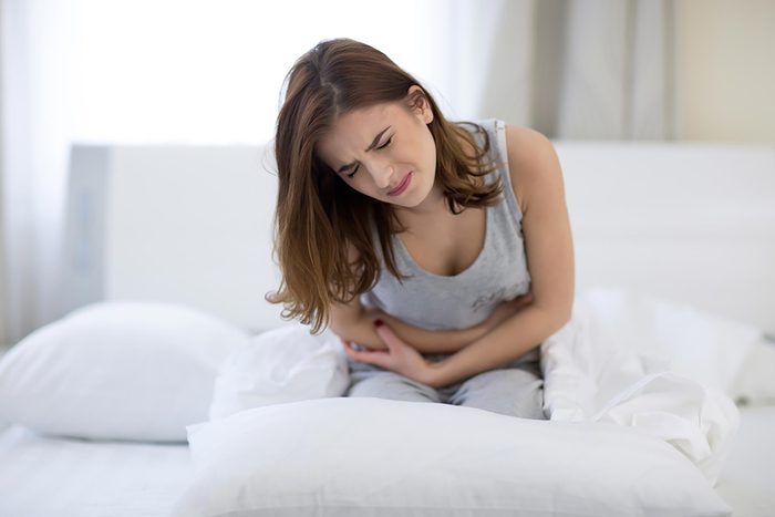 woman in bed in pain with a stomachache