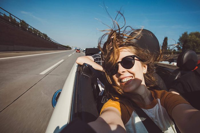 woman taking a selfie in a convertible car