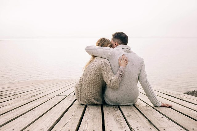 man and woman hugging on a dock