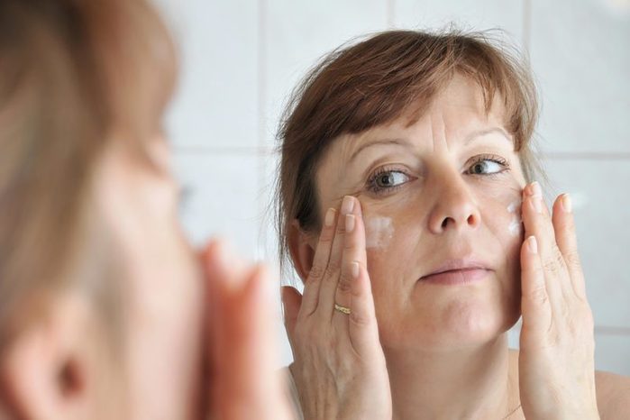 woman applying white face cream