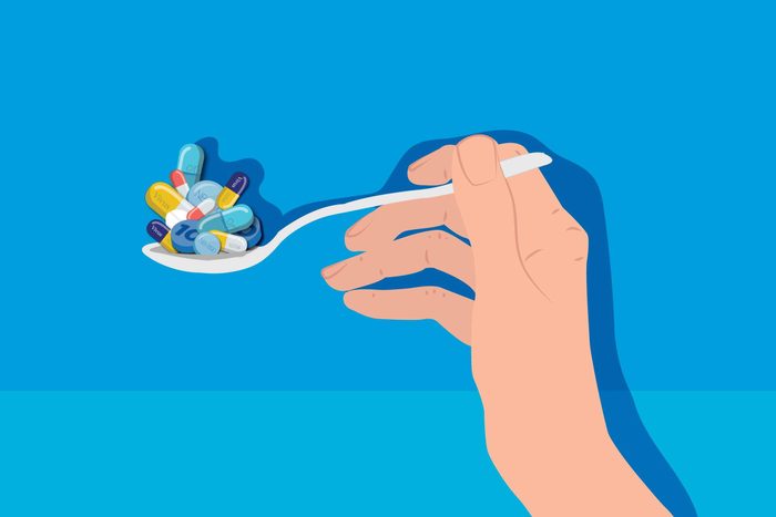 Illustration of a hand holding a spoonful of pills and capsules.