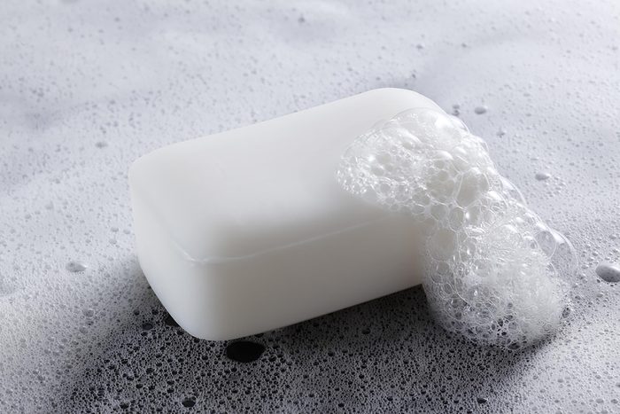 White bar of soap with suds on it.
