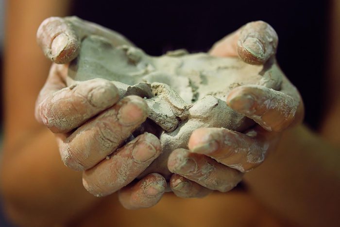 Closeup of hands cupping Bentonite-Clay