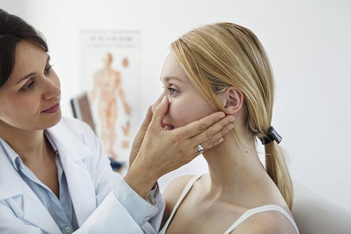 female doctor checking the sinuses of a female patient
