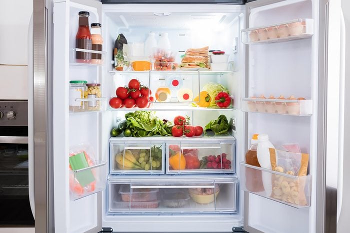 an open refrigerator filled with fruits and vegetables