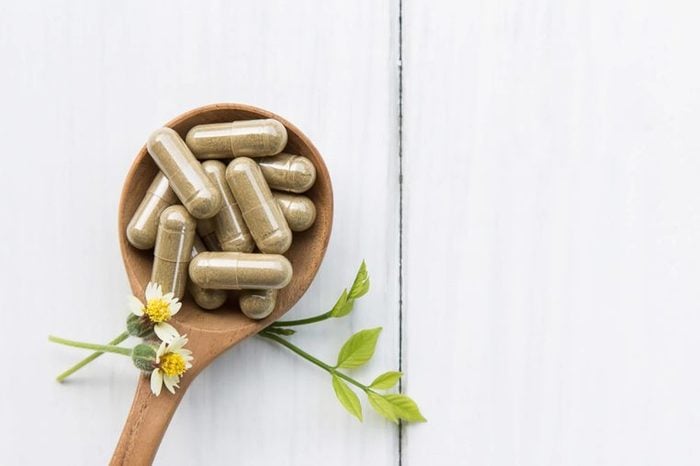 Supplement capsules on a wooden spoon