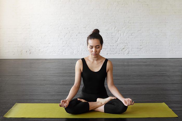 woman doing meditation exercise on mat