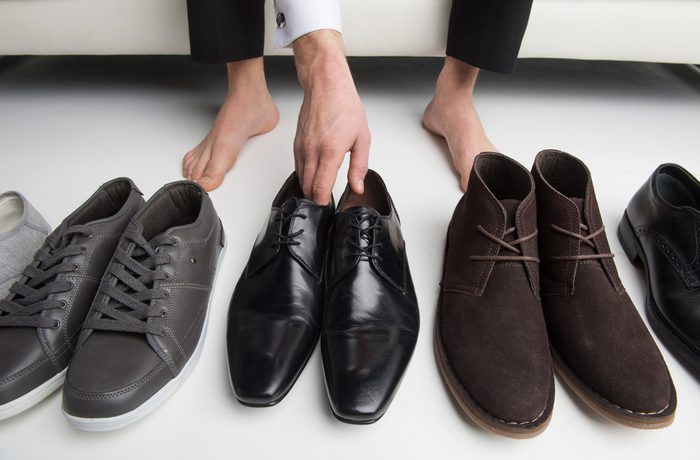 man chooses which pair of shoes to wear