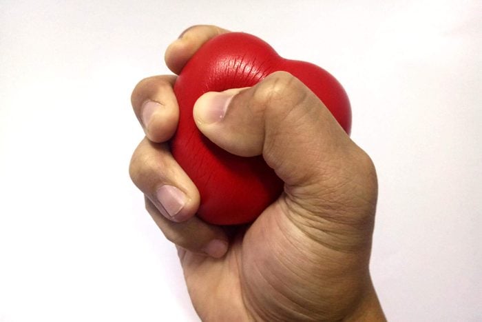 hand squeezing red stress heart