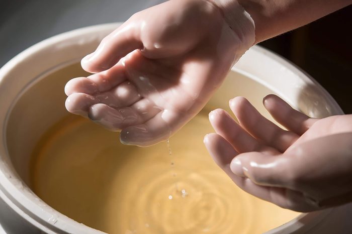 hands above a paraffin wax bath bowl
