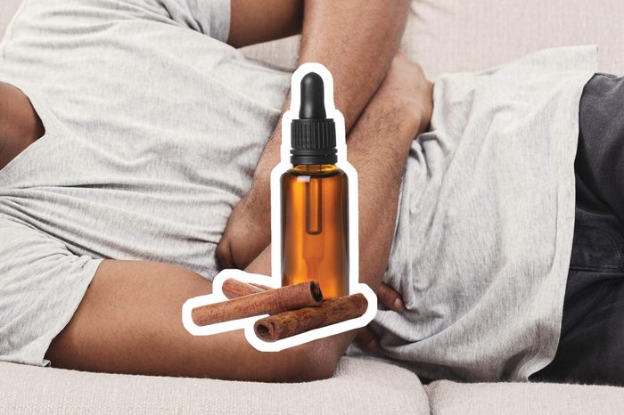 Cinnamon oil over a reclining man holding his stomach